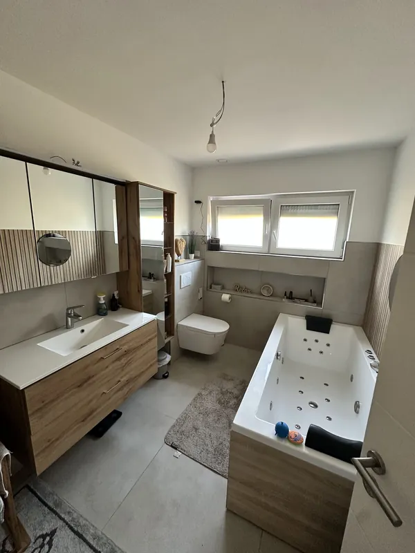 Neues Bad mit Whirlpool-Wanne, Holzwaschtisch und Großformatfliesen in Kaarst